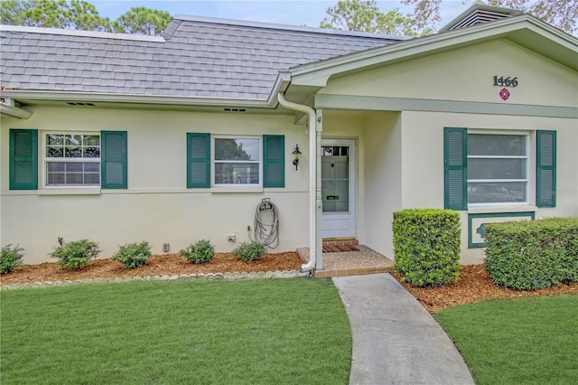 view of exterior entry featuring a yard