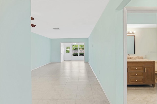 hallway featuring light tile patterned floors and an inviting chandelier