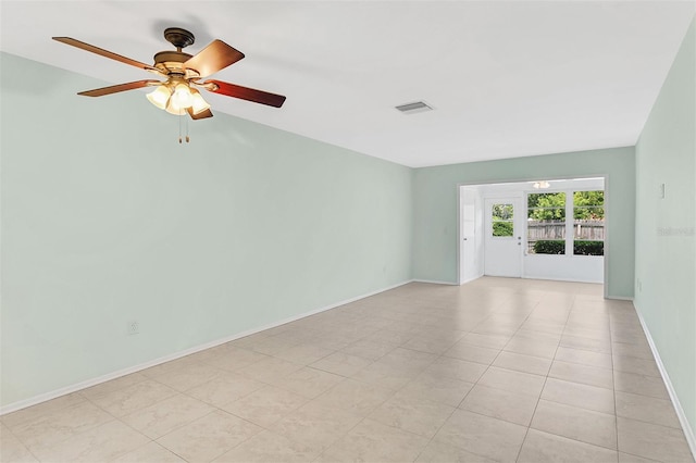 tiled empty room featuring ceiling fan