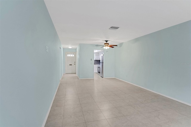 unfurnished room with ceiling fan and light tile patterned floors