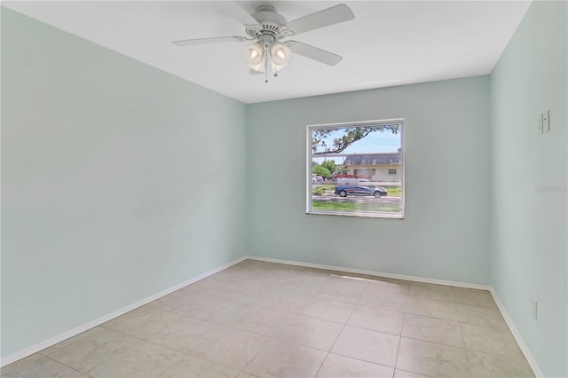 tiled spare room featuring ceiling fan