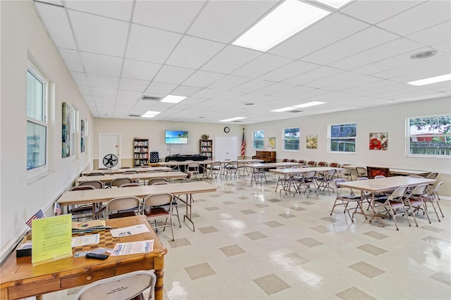 dining area with a paneled ceiling, a healthy amount of sunlight, and light tile patterned floors