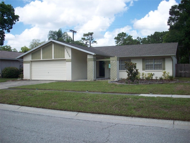 ranch-style home featuring a garage and a front lawn