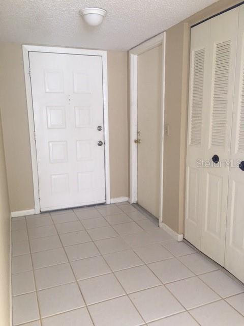 tiled entrance foyer featuring a textured ceiling