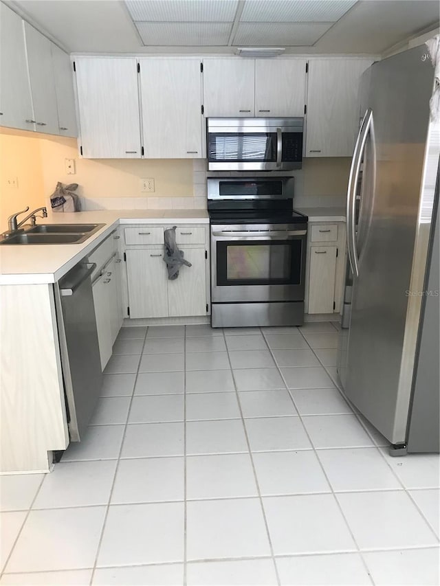 kitchen with stainless steel appliances, sink, and light tile patterned floors