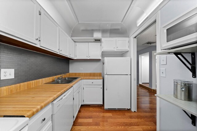 kitchen featuring white cabinetry, tasteful backsplash, white appliances, hardwood / wood-style floors, and sink