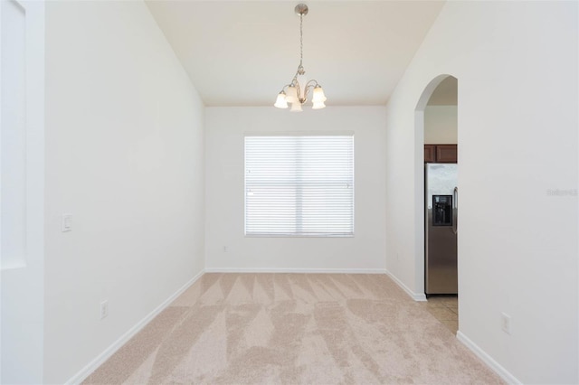 carpeted spare room featuring lofted ceiling and a notable chandelier