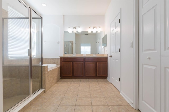 bathroom with vanity, a healthy amount of sunlight, tile patterned floors, and plus walk in shower