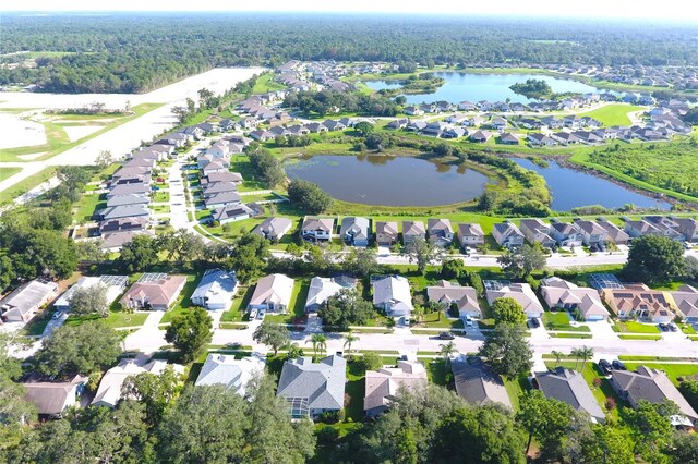 birds eye view of property with a wooded view, a water view, and a residential view