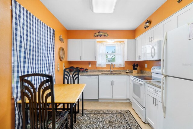 kitchen featuring white cabinetry, light stone countertops, white appliances, and sink