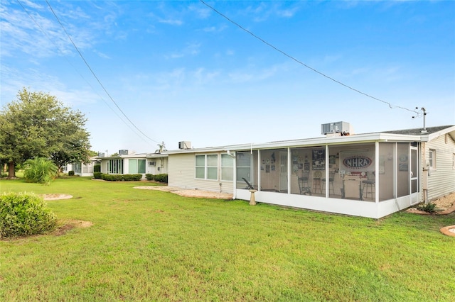 back of property featuring a sunroom and a yard