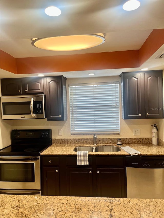 kitchen featuring dark brown cabinetry, sink, and appliances with stainless steel finishes