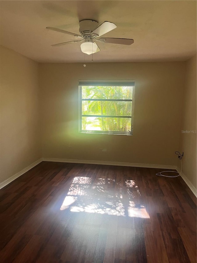 empty room with ceiling fan and dark hardwood / wood-style flooring