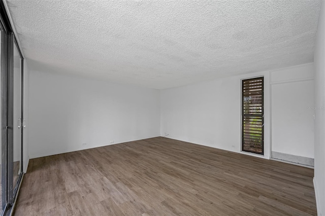 spare room with a textured ceiling and wood finished floors