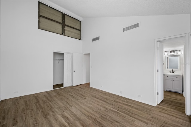 unfurnished bedroom featuring visible vents, a sink, and wood finished floors