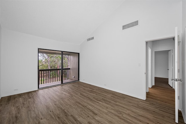 spare room featuring high vaulted ceiling, baseboards, visible vents, and dark wood finished floors