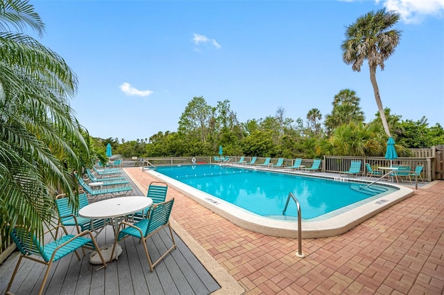 community pool with fence and a patio