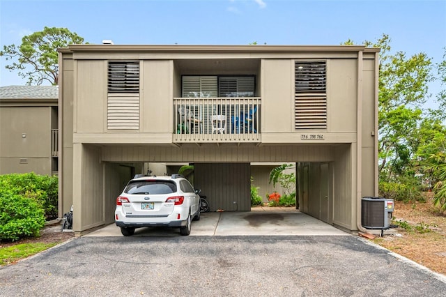 view of front facade with a carport, central AC, and driveway