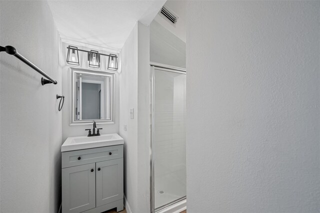 full bath with a shower stall, visible vents, and vanity