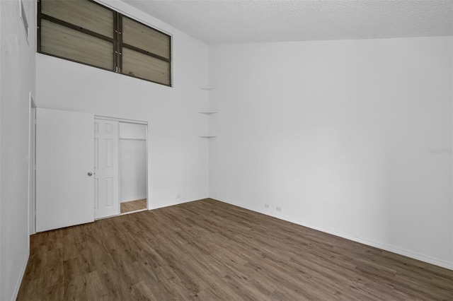 spare room featuring a textured ceiling and dark wood-type flooring