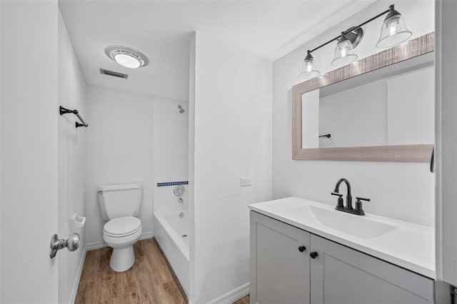 bathroom with visible vents, toilet, wood finished floors, vanity, and a bath