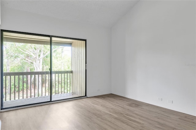 spare room featuring light wood-style flooring and a textured ceiling