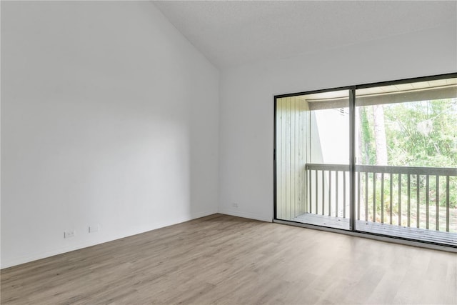 unfurnished room with lofted ceiling, light wood-style flooring, and baseboards