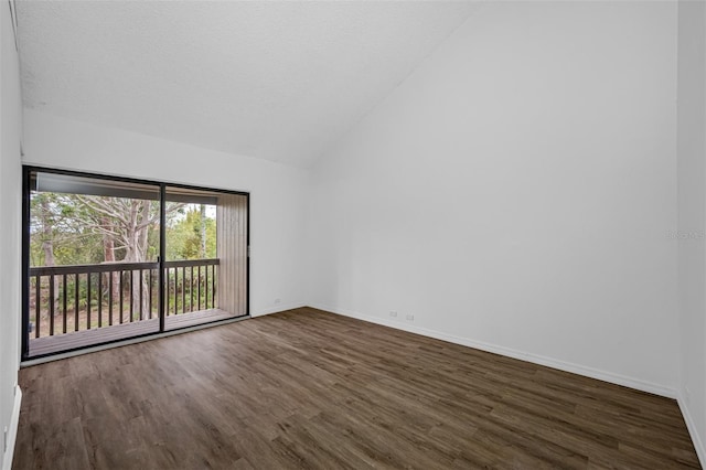 spare room featuring vaulted ceiling, dark wood-type flooring, a textured ceiling, and baseboards