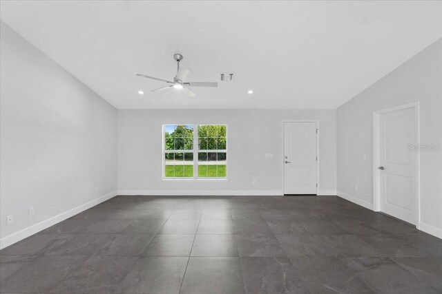 tiled empty room featuring ceiling fan