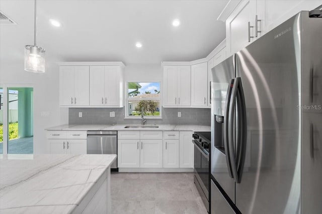 kitchen featuring sink, a healthy amount of sunlight, light tile patterned floors, and stainless steel appliances