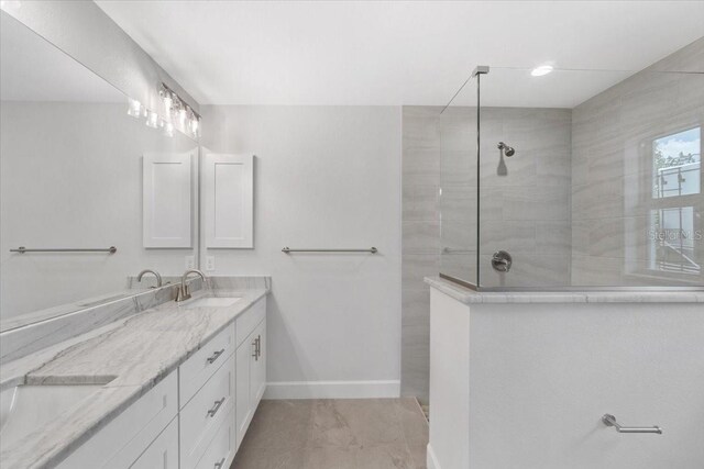 bathroom with tile patterned flooring, tiled shower, and dual bowl vanity