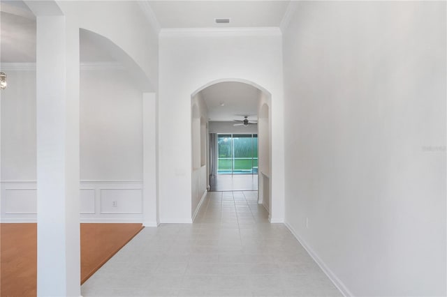 corridor with light tile patterned flooring and crown molding