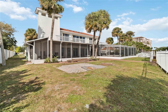 rear view of property with a lawn and a sunroom