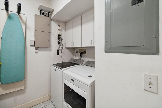 laundry area featuring light tile patterned floors, cabinets, electric panel, and washer and clothes dryer