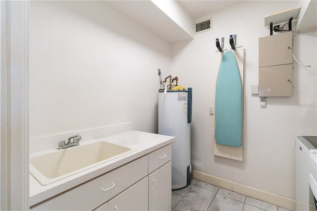 laundry area with water heater, sink, and light tile patterned floors