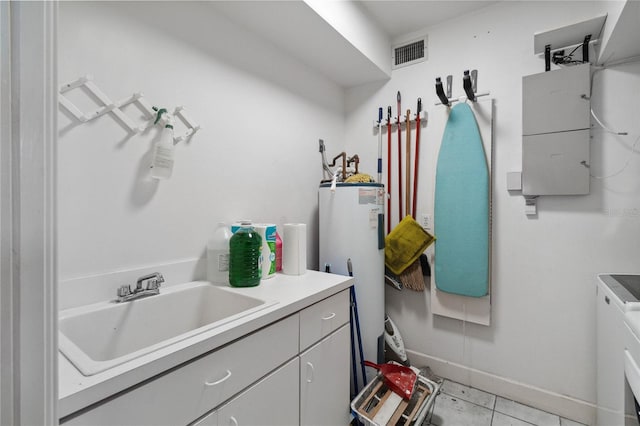 clothes washing area featuring light tile patterned floors, sink, and water heater