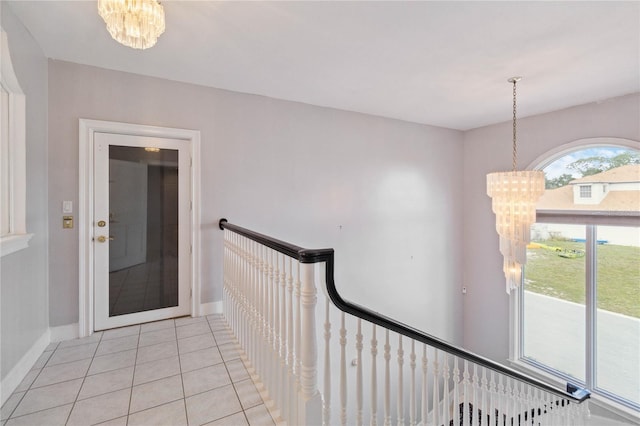 hallway featuring a notable chandelier and light tile patterned floors