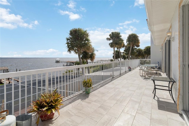 view of patio / terrace with a water view and a balcony