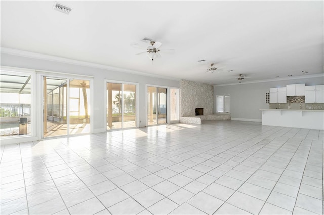 unfurnished living room with a premium fireplace, ornamental molding, ceiling fan, and light tile patterned floors