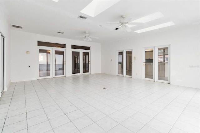 tiled spare room featuring french doors, ceiling fan, and a skylight