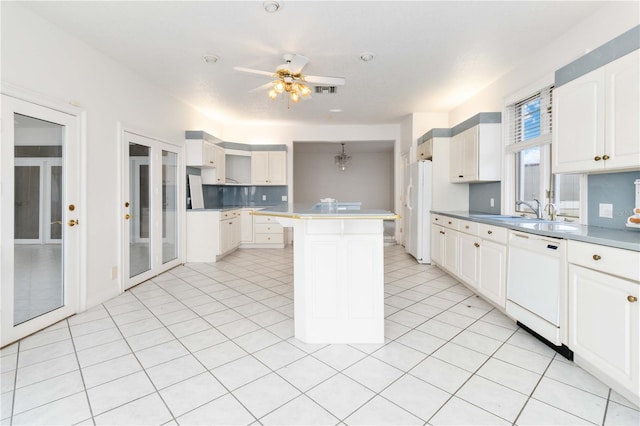 kitchen featuring ceiling fan, white cabinetry, sink, a center island, and white appliances