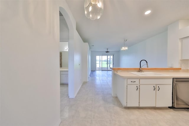 kitchen with dishwasher, white cabinetry, sink, hanging light fixtures, and an inviting chandelier