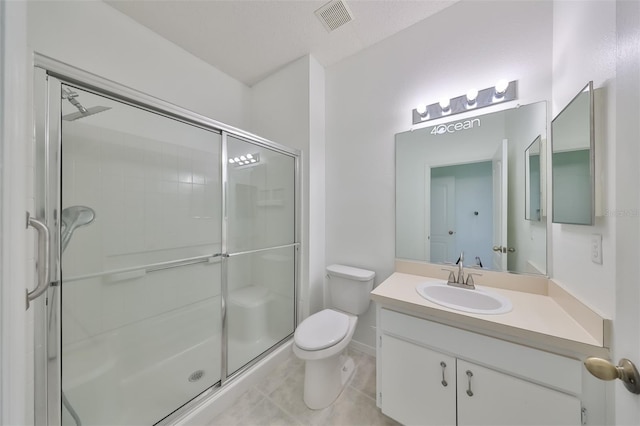 bathroom featuring an enclosed shower, vanity, tile patterned floors, and toilet