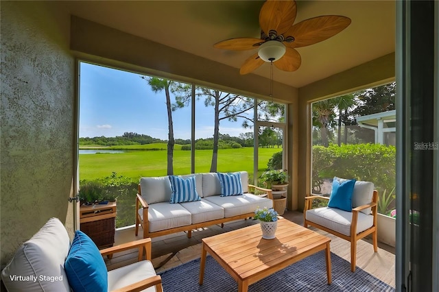 sunroom featuring a water view and ceiling fan