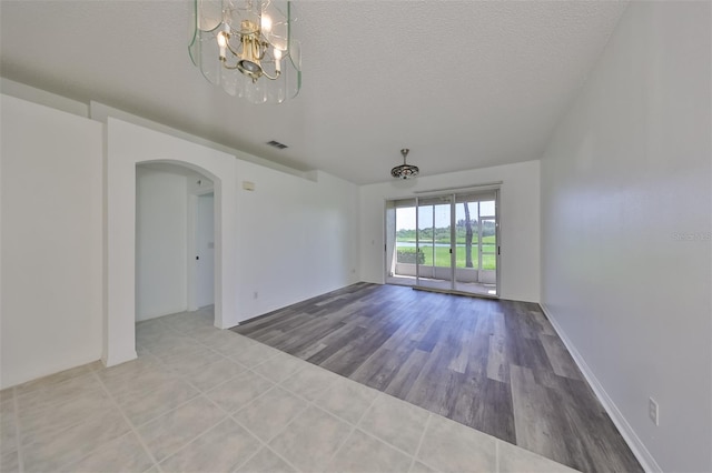 empty room with hardwood / wood-style flooring and a textured ceiling