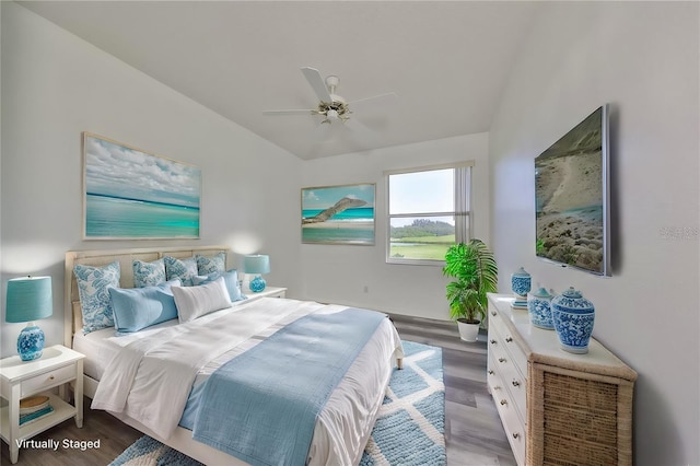 bedroom featuring ceiling fan, wood-type flooring, and vaulted ceiling