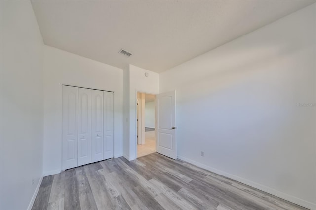 unfurnished bedroom with a closet and light wood-type flooring