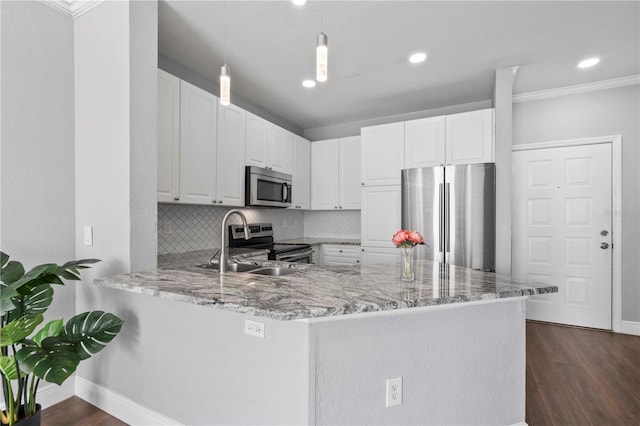 kitchen with sink, white cabinets, appliances with stainless steel finishes, and kitchen peninsula