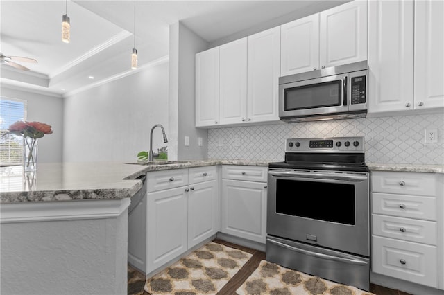 kitchen featuring white cabinets, appliances with stainless steel finishes, sink, kitchen peninsula, and crown molding