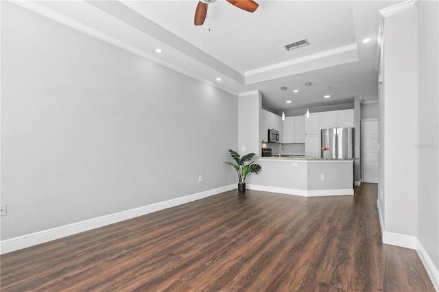 unfurnished living room with a raised ceiling, ceiling fan, dark hardwood / wood-style floors, and ornamental molding